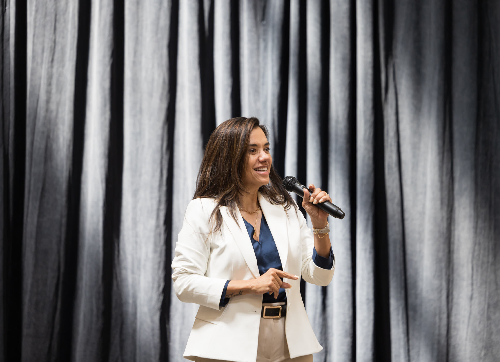 Christiane Drew speaking on stage with a microphone